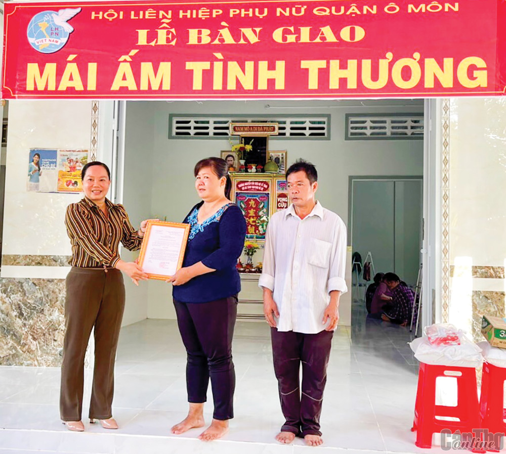Bà Võ Thị Thúy Đoan, Chủ tịch Hội LHPN quận Ô Môn, trao quyết định tặng Mái ấm tình thương cho gia đình chị Nguyễn Thị Thu Huệ.