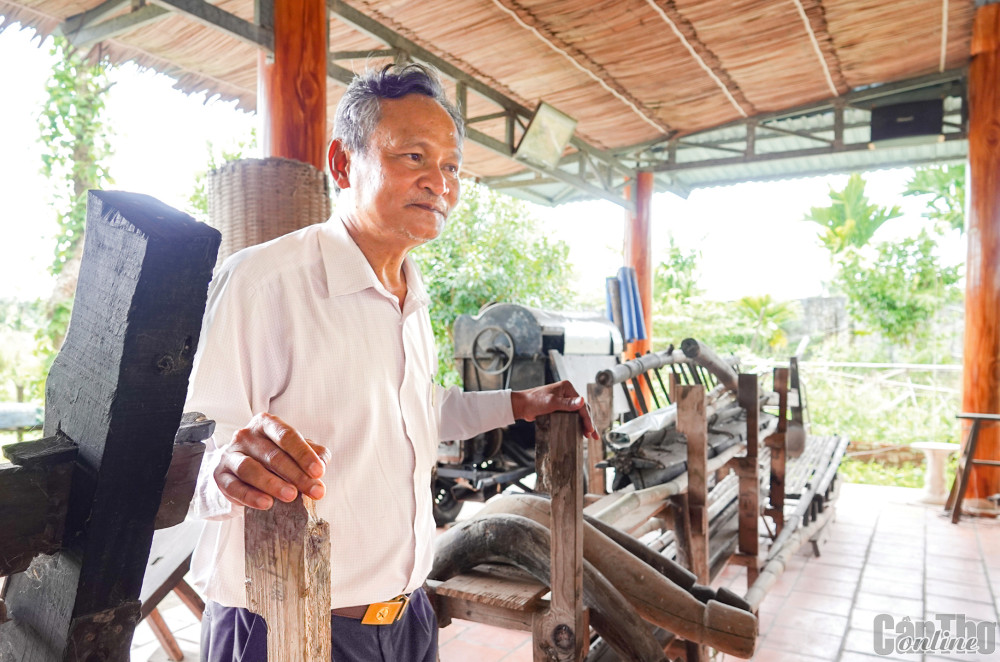 Ông Tư Việt bên các nông cụ tái hiện quy trình trồng và thu hoạch, bảo quản lúa mùa. Ảnh: DUY KHÔI