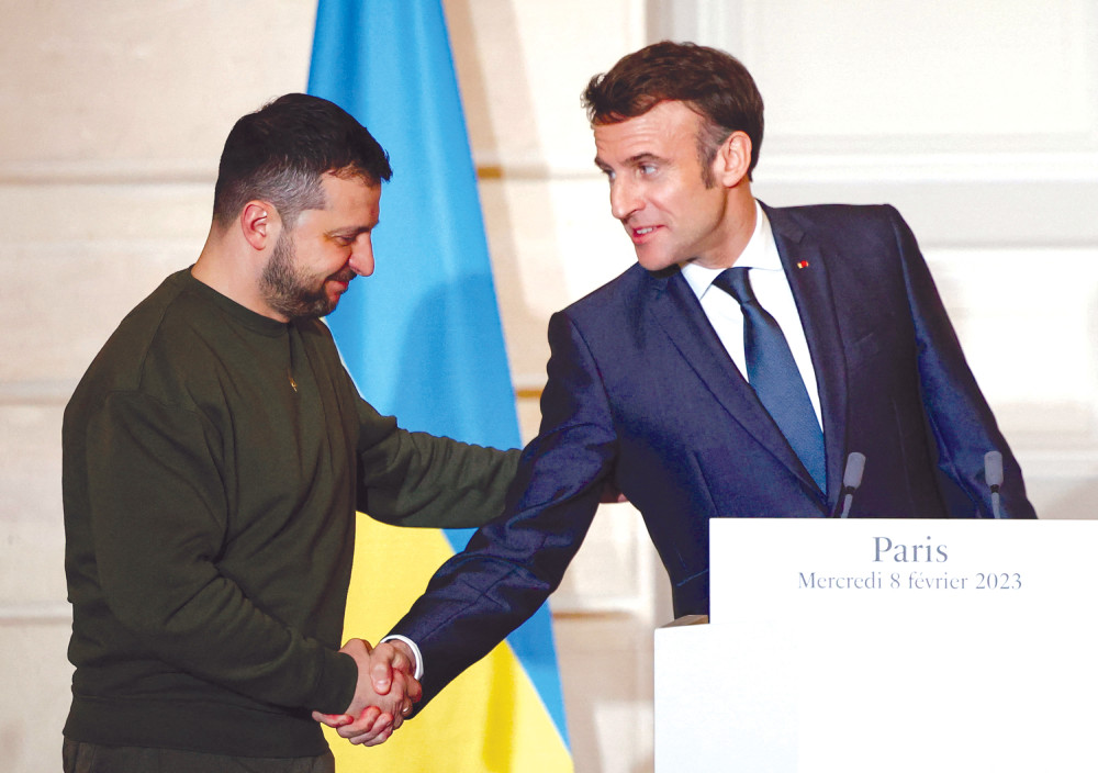 Tổng thống Ukraine Zelensky (trái) và người đồng cấp Pháp Macron đi cùng chuyến bay sang Brussels dự Hội nghị thượng đỉnh của EU. Ảnh: Reuters