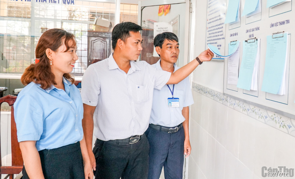 Công chức xã Trung An theo dõi, giám sát kết quả thu chi do UBND xã niêm yết.