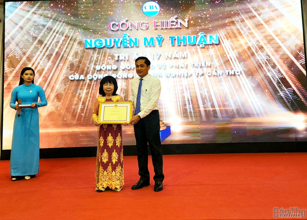 Ông Nguyễn Văn Hồng trao bằng khen của UBND thành phố cho bà Nguyễn Mỹ Thuận