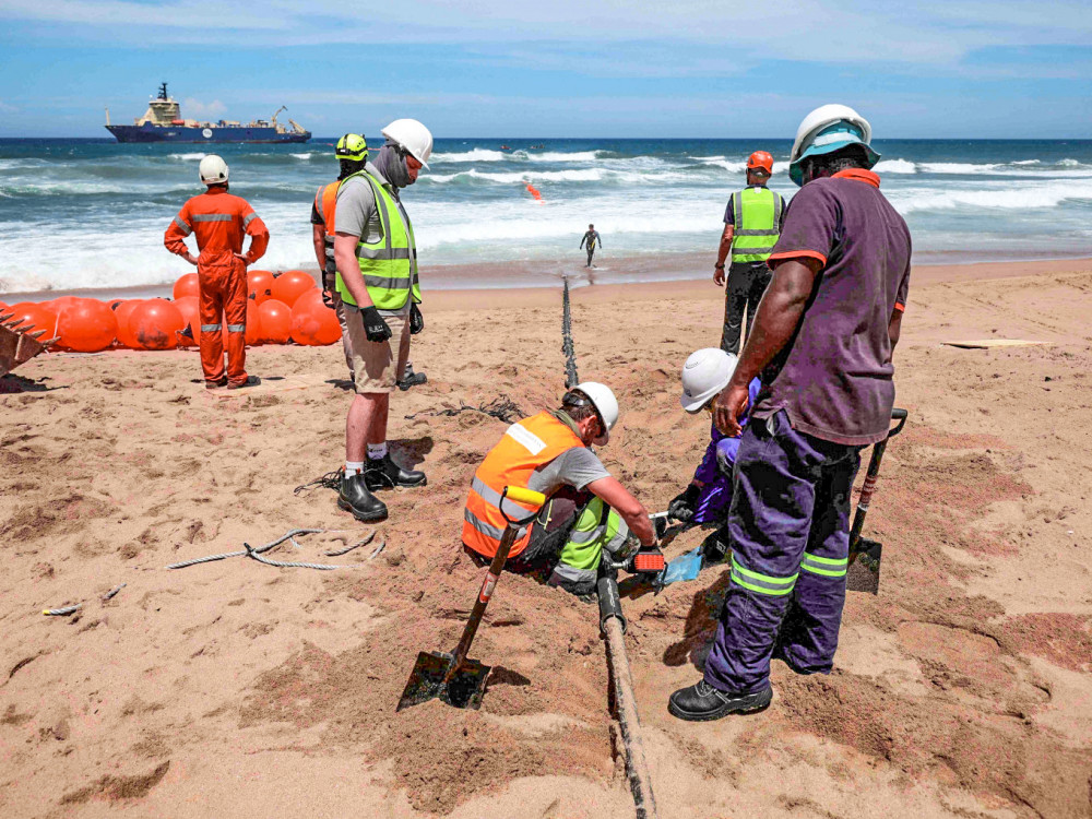 Công nhân lắp đặt cáp quang biển trên bãi biển ở Nam Phi. Ảnh: Reuters
