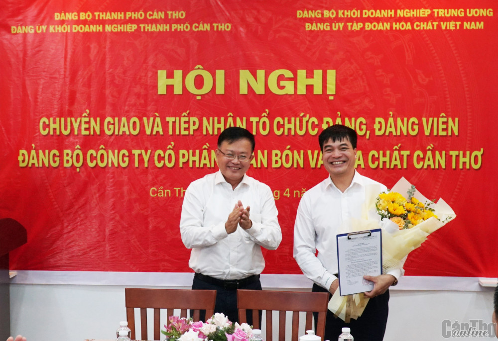 Đồng chí Nguyễn Trung Nhân (bên trái) trao quyết định chuyển giao tổ chức cơ sở đảng và đảng viên cho đại diện Đảng ủy Tập đoàn Hóa chất Việt Nam. Ảnh: ANH DŨNG