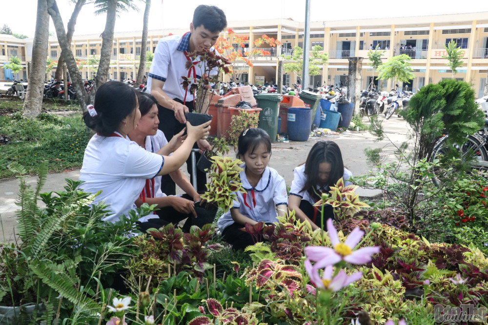 Đội viên Liên đội Trường THCS và THPT Trần Ngọc Hoằng (huyện Cờ Đỏ) trồng hoa kiểng tạo khuôn viên trường học xanh - sạch - đẹp.