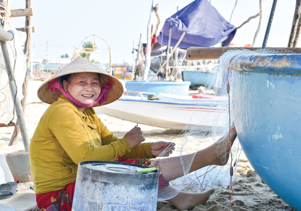 Phụ nữ xóm chài Trần Phú, TP Phú Quốc, vá lưới chuẩn bị cho chuyến ra khơi mới của chồng.
