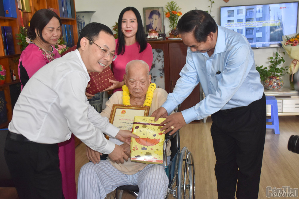 Đồng chí Nguyễn Văn Hiếu (bìa trái) trao Thiếp mừng thọ 100 tuổi tặng cụ ông Lê Văn Lai ở phường Bình Thủy, quận Bình Thủy. Ảnh: K.XUÂN