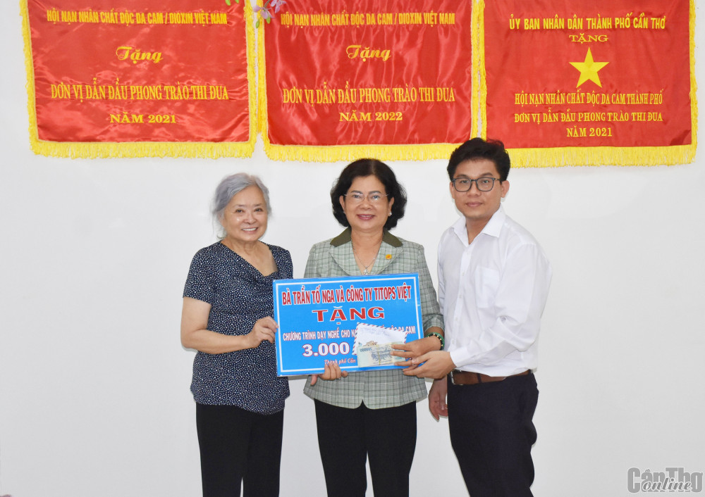Bà Trần Tố Nga (bìa trái), ông Nguyễn Hoài Tưởng, Giám đốc Công ty Titops Việt Nam tại TP Cần Thơ trao số tiền tài trợ cho các NNCĐDC/dioxin trên địa bàn thành phố.