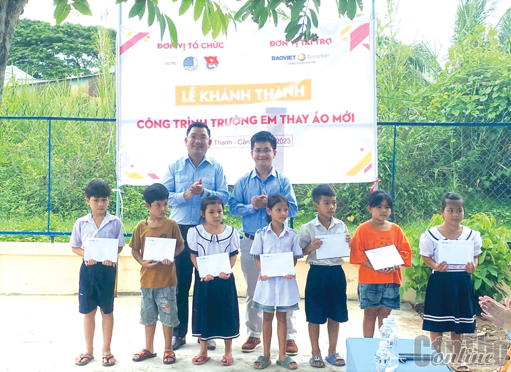 Anh Lâm Văn Tân (bìa trái, hàng sau), Phó Bí thư Thành đoàn Cần Thơ, trao học bổng cho học sinh có hoàn cảnh khó khăn trên địa bàn huyện Vĩnh Thạnh.