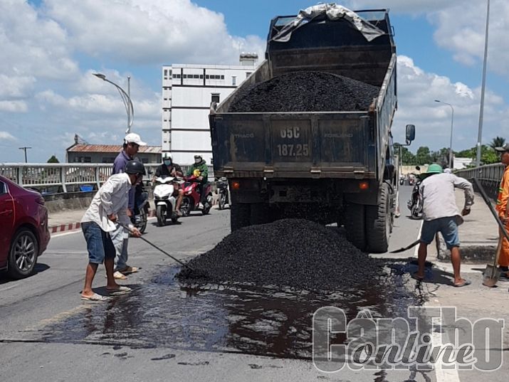 Công nhân giặm vá mặt cầu Cái Sơn.