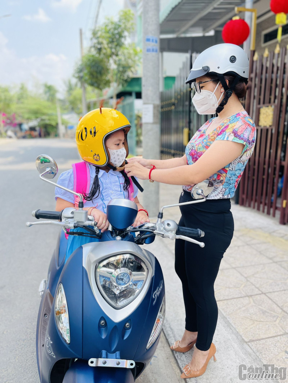 Hội viên phụ nữ quận Ô Môn đội nón bảo hiểm cho trẻ khi tham gia giao thông.