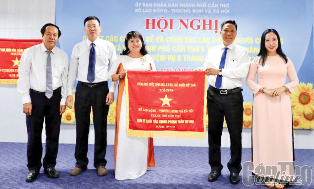 Ông Nguyễn Thực Hiện, Phó Chủ tịch UBND thành phố, trao Cờ thi đua của Chính phủ cho Ban Giám đốc Sở LĐ-TB&XH thành phố, đơn vị xuất sắc trong phong trào thi đua năm 2022. Ảnh: Sở LĐ-TB&XH thành phố cung cấp.