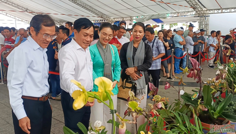 Ông Nguyễn Ngọc Hè (thứ 2 từ trái sang) và các đại biểu tham quan, thưởng lãm gian hàng trưng bày của Group hoa phong lan lá kẻ - phát tài miền Nam.