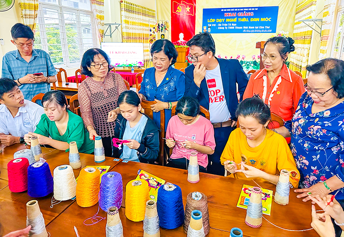 Các đại biểu xem giáo viên hướng dẫn học viên đan len.