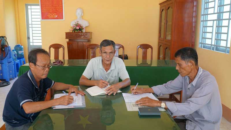 Ông Phạm Minh Chánh (ngồi giữa) họp bàn với các cán bộ ấp về kế hoạch tuyên truyền, vận động nhân dân tham gia bảo hiểm y tế. 