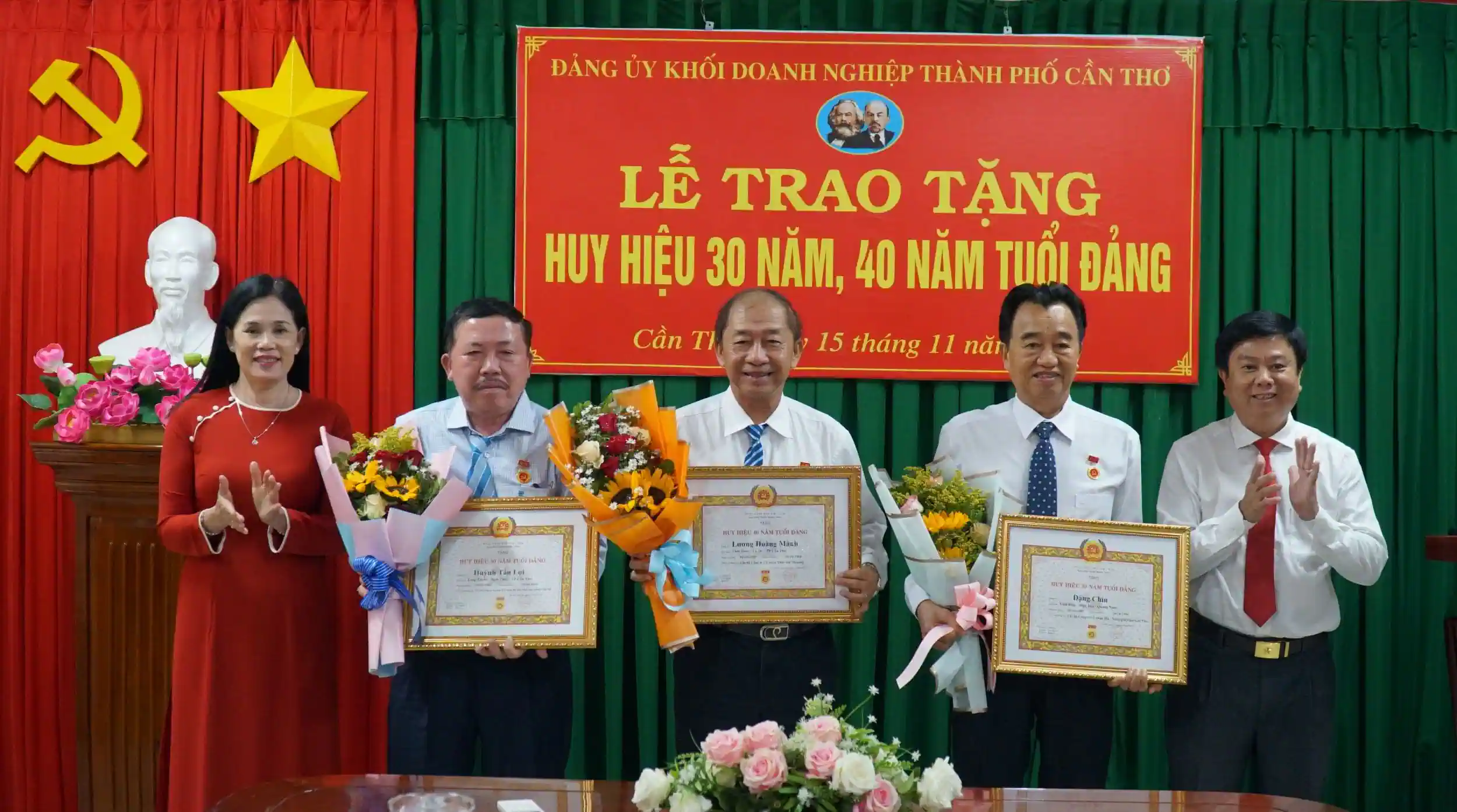 Thường trực Đảng ủy Khối Doanh nghiệp thành phố trao Huy hiệu Đảng và tặng hoa chúc mừng các đảng viên. Ảnh: ANH DŨNG