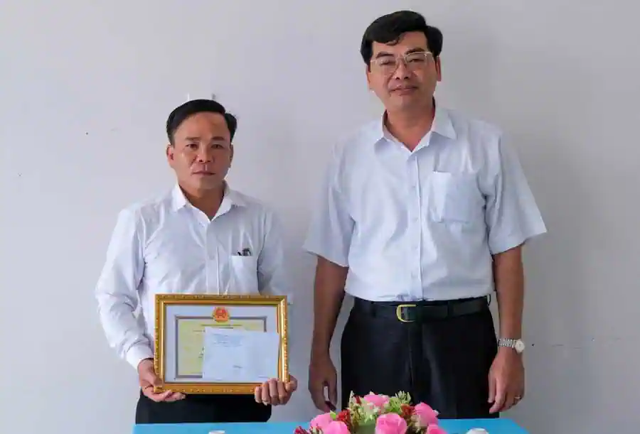 Ông Trần Thanh Bình, Giám đốc Sở GD&ĐT thành phố (phải) trao khen thưởng đến thầy Nguyễn Nhựt Tân. Ảnh: DUY KHÔI