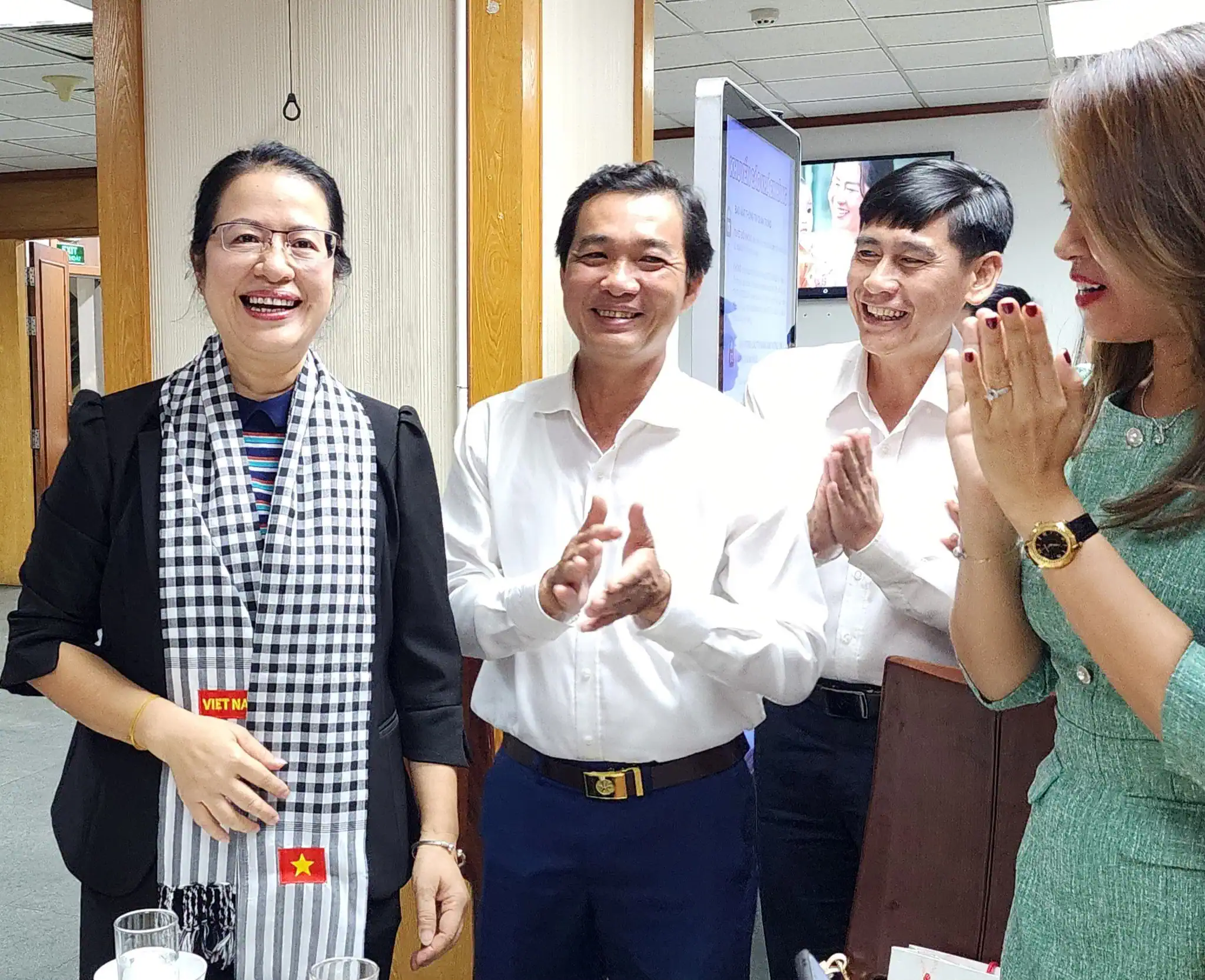 Nhà báo Trương Văn Chuyển đại diện đoàn công tác trao tặng chiếc khăn rằn lưu niệm đến bà Nguyễn Thị Phượng, Phó Tổng giám đốc Agribank (bìa trái).