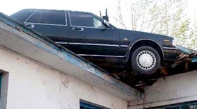 Xe hơi bị thổi lên nóc nhà