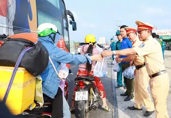 Cảnh sát giao thông Trạm Thới Thuận phát nước suối cho người dân về quê ăn Tết Ất Tỵ năm 2025