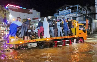 Nhiều tình nguyện viên hỗ trợ người dân khi xe bị chết máy do triều cường và mưa lớn